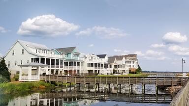 Panoramic view of riverfront homes and boats along the boardwalk in Washington NC