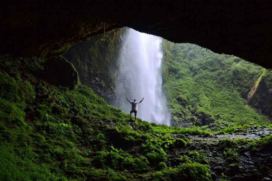 Man admiring Puxtla waterfall with arms in the air near Tlatlauquitepec in Mexico