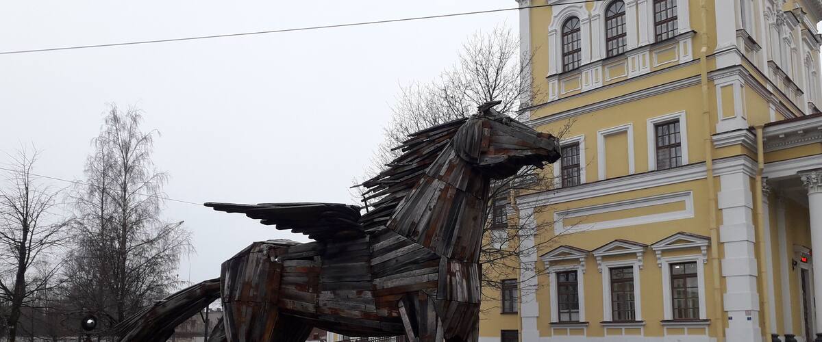 A large metal sculpture of a horse in an urban setting.