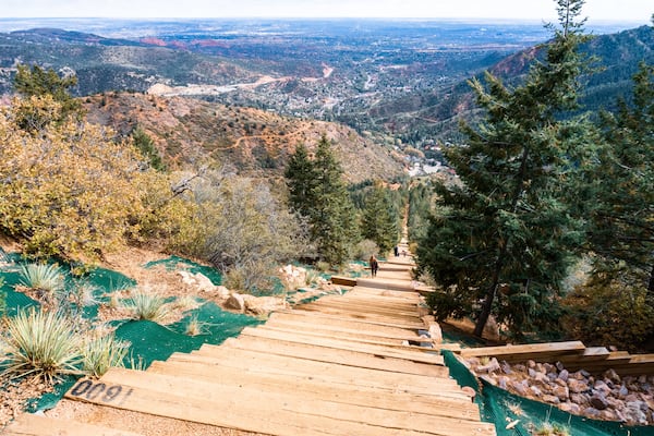 Un escalier en bois menant vers le haut, d’où l’on peut admirer une vallée en contrebas.