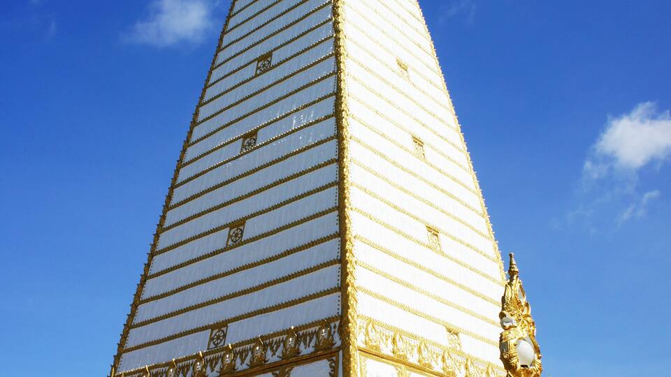 A large, ornate golden stupa with intricate designs and a tall spire.