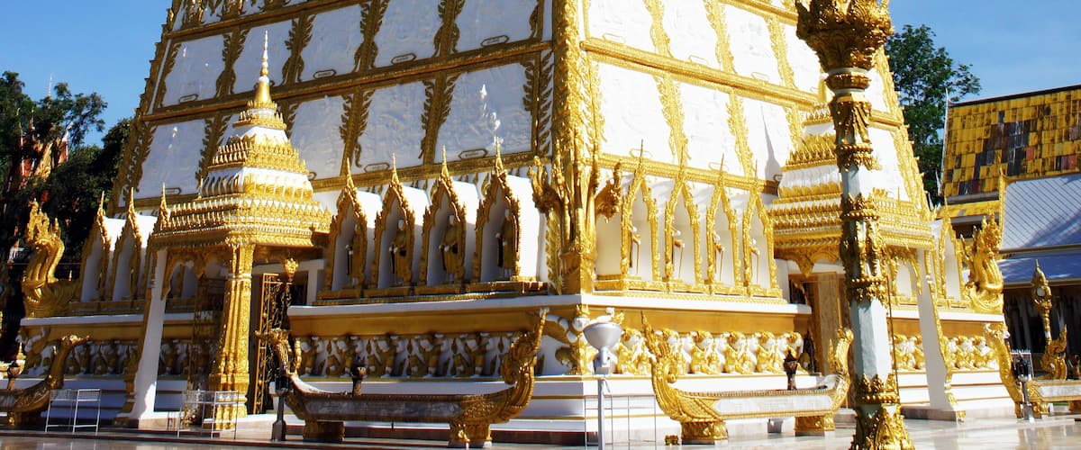 A large, ornate golden stupa with intricate designs and a tall spire.