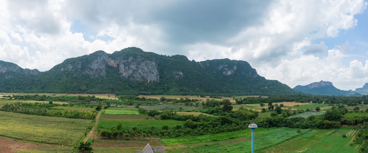 A mountainous landscape with fields and a river.