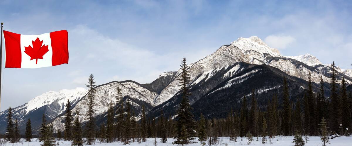 Blaeberry River, near Golden, British Columbia, Canada. Beautiful panoramic Canadian Landscape View of Frozen water and mountains in winter. With Flag Composite