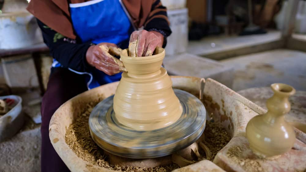 Closeup of Local woman demonstrates on making traditional clay jar called "Labu Sayong" or Essence Jar of Sayong in Kuala Kangsar, Perak, Malaysia.