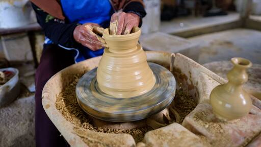 Closeup of Local woman demonstrates on making traditional clay jar called "Labu Sayong" or Essence Jar of Sayong in Kuala Kangsar, Perak, Malaysia.