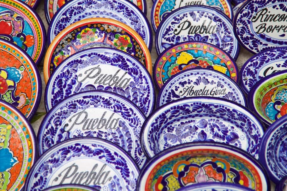 Un conjunto de platos de cerámica coloridos con diseños elaborados y texto.