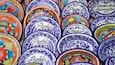 A collection of colorful ceramic plates with intricate designs and text.