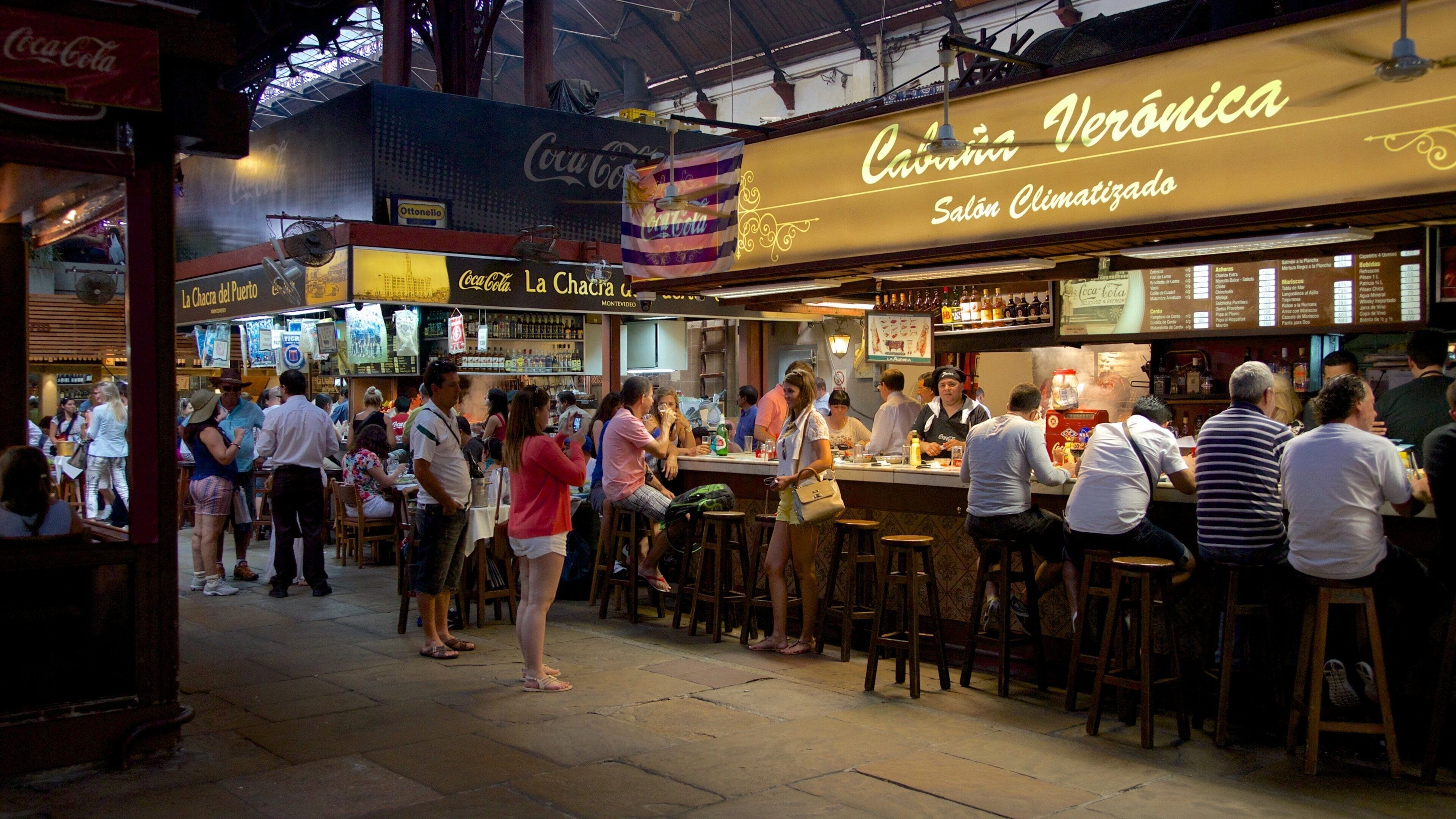 Mercado Agricola de Montevideo featuring a bar as well as a large group of people