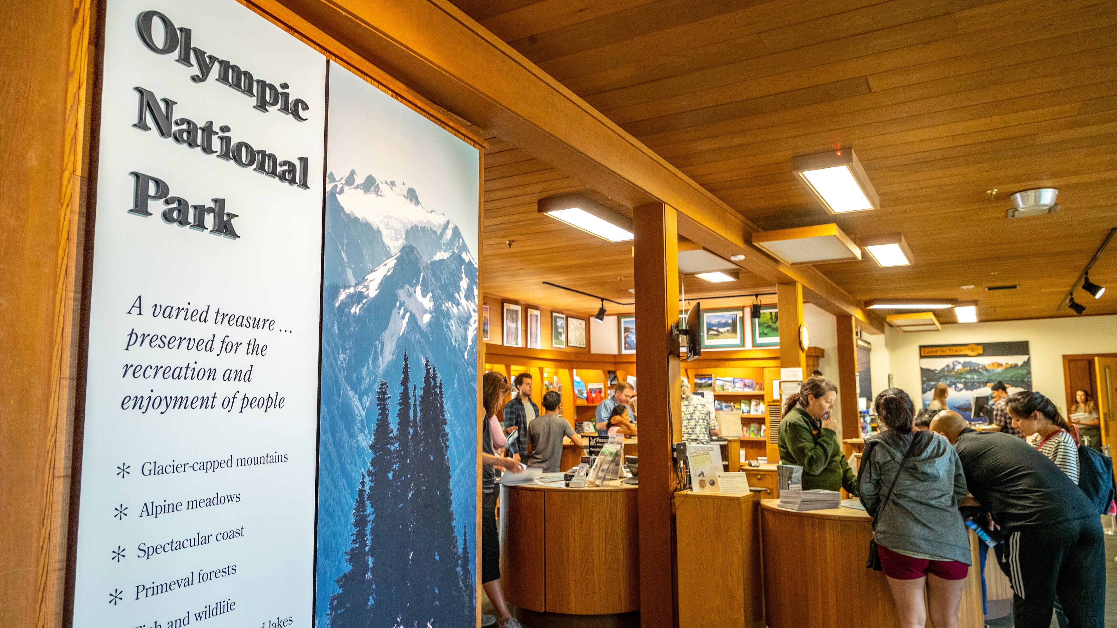 Olympic National Park Visitor Center featuring interior views and signage as well as a small group of people