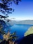 A clear blue lake surrounded by forested hills.
