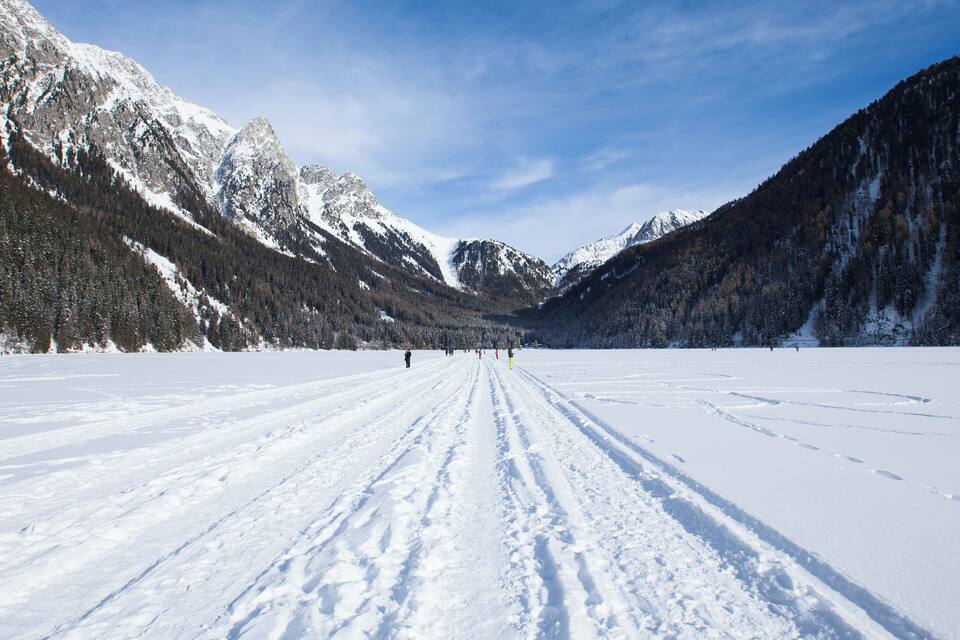 A snow-covered valley with mountains in the background.