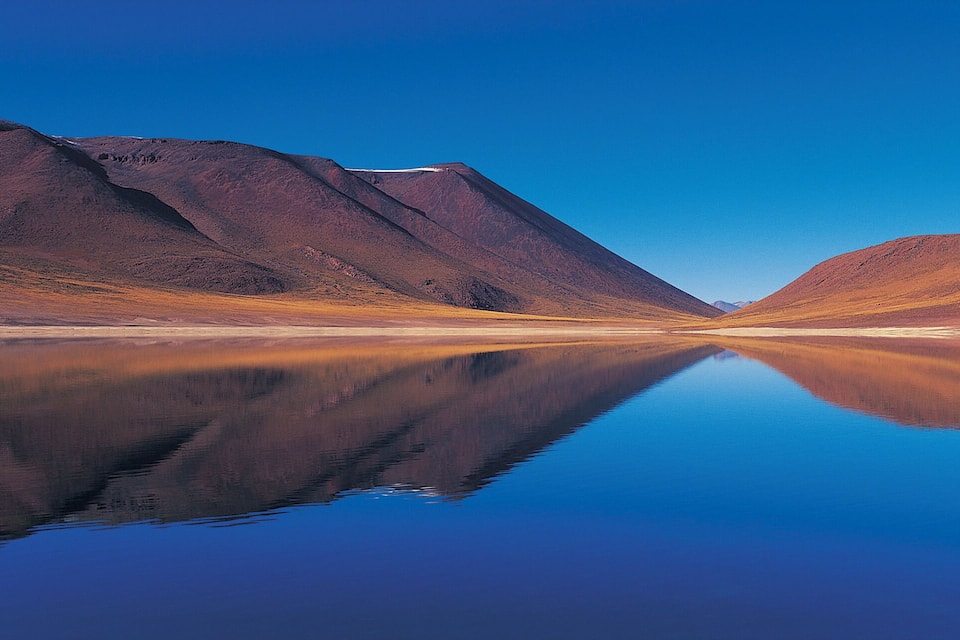 Ein stiller See spiegelt Berge wider.