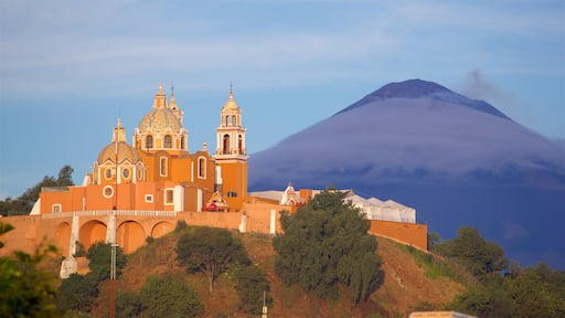 Santuário La Virgen de los Remedios caracterizando elementos de patrimônio, um pôr do sol e montanhas
