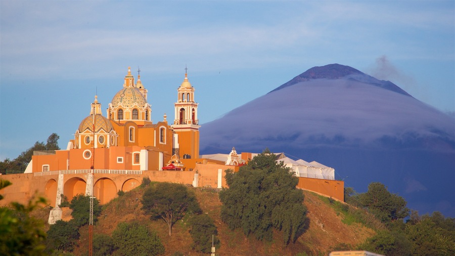 La Virgen de los Remedios Sanctuary showing mountains, a sunset and heritage elements
