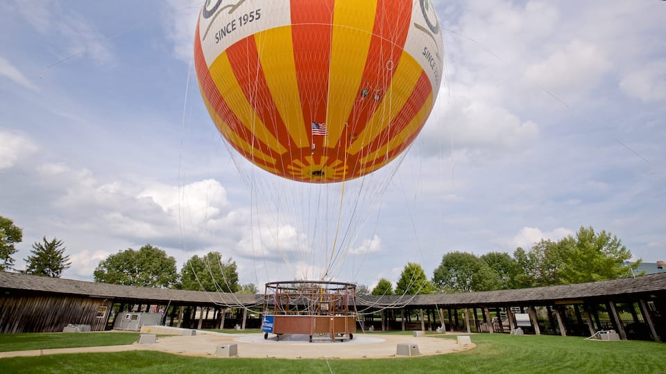 A hot air balloon with a red and yellow design, tethered to a wooden structure.