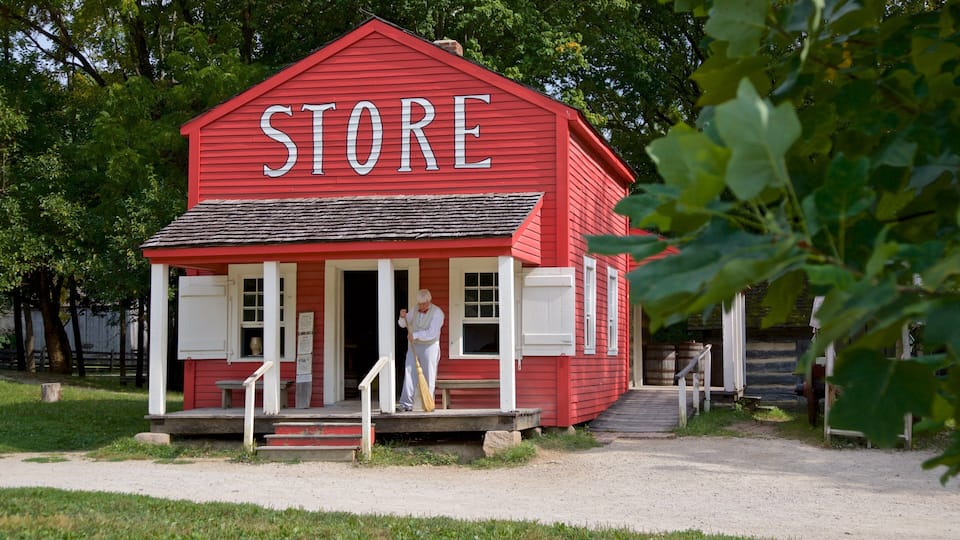 A red store with white trim and a person standing at the entrance.