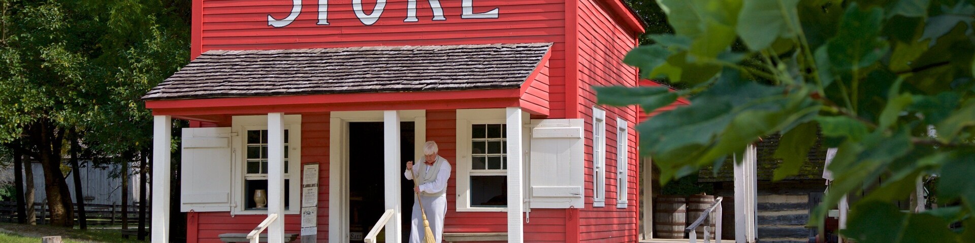 Conner Prairie Interactive History Park ofreciendo un pueblo y señalización y también un hombre