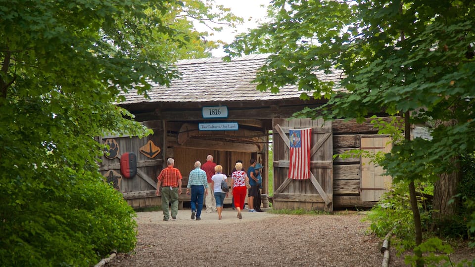 A wooden building with a sign reading "1816 Two Cultures, One Land" and an American flag.