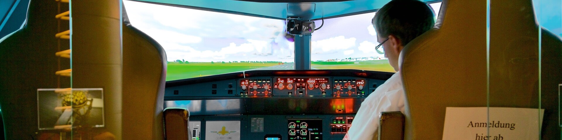 Le poste de pilotage d’un avion, avec de nombreux panneaux de contrôle et une vue sur la piste à travers le pare-brise.