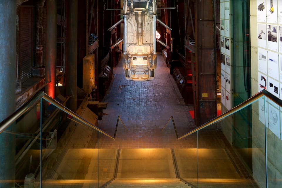 A museum corridor with industrial exhibits and a central display case.