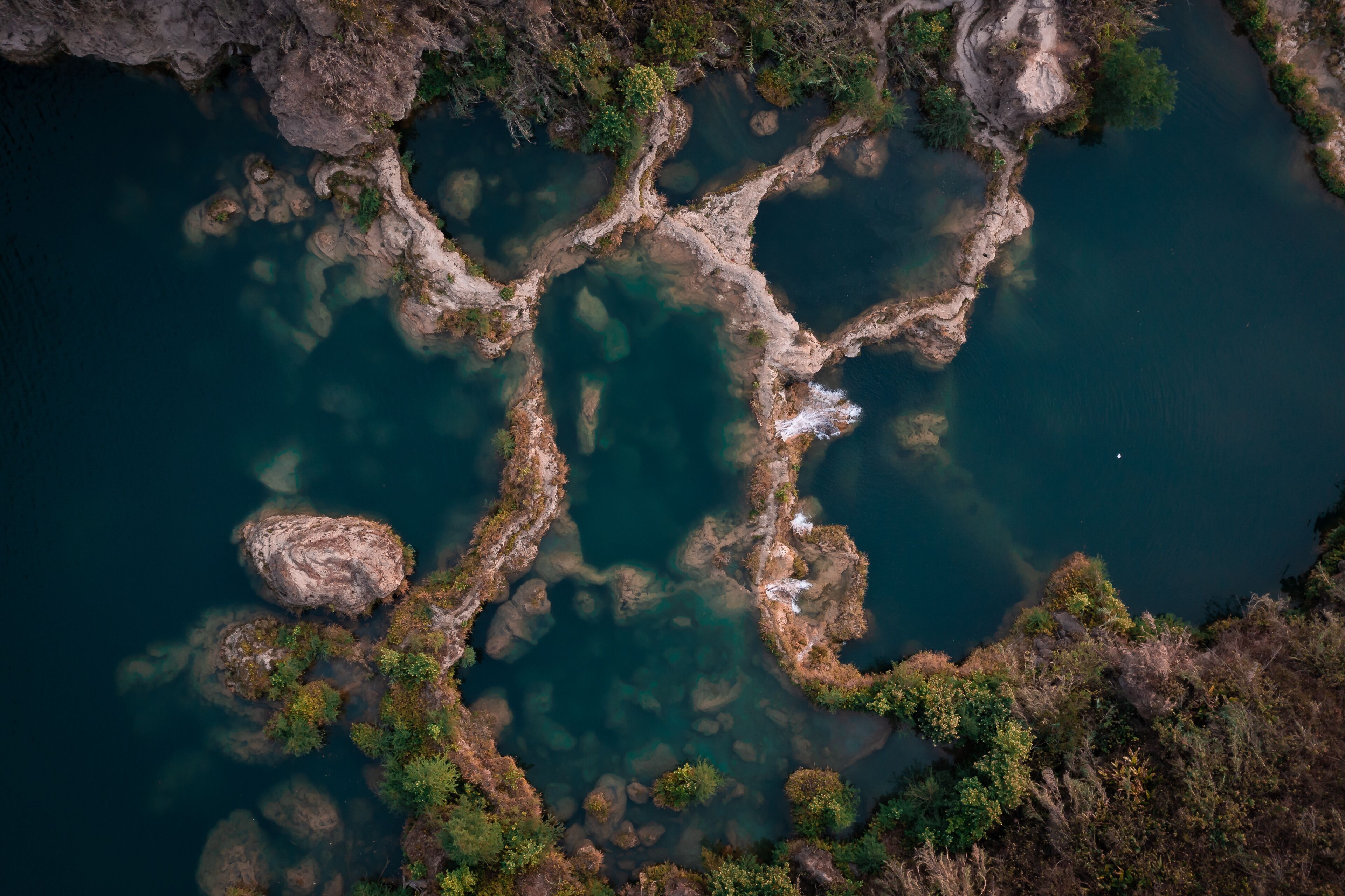Aerial view of the cascading waters of Tamasopo River, where the river carves through the landscape creating a mesmerizing mosaic of turquoise pools, San Luis Potosi, San Luis Potosi, Mexico.