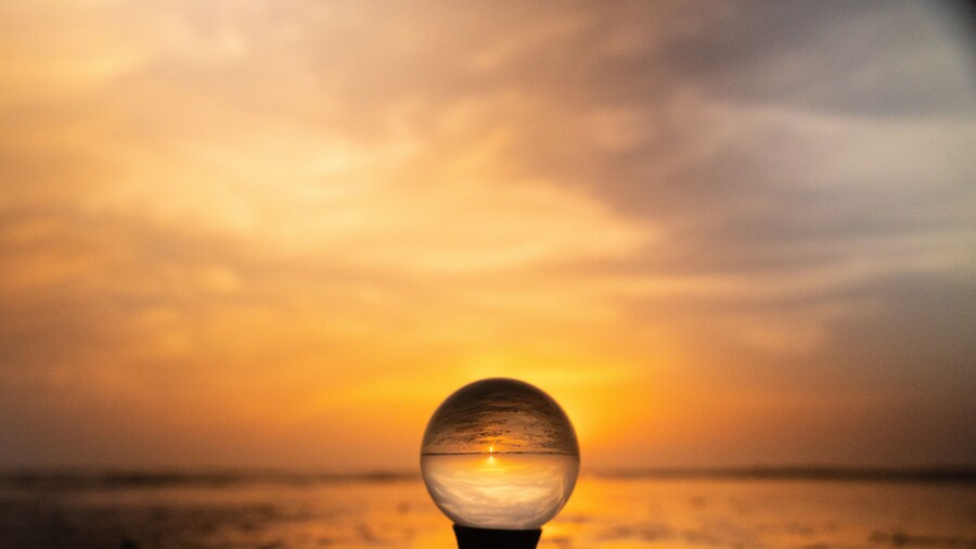 Colorful yellow, orange sunrise at the beach, reflected in crystal lens ball on a stand glass photography ball reflecting the colors of the sunrise at North Padre Island National Seashore in Texas