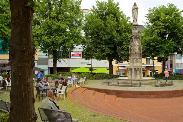 Place Marienplatz Paderborn montrant fontaine et statue ou sculpture aussi bien que petit groupe de personnes