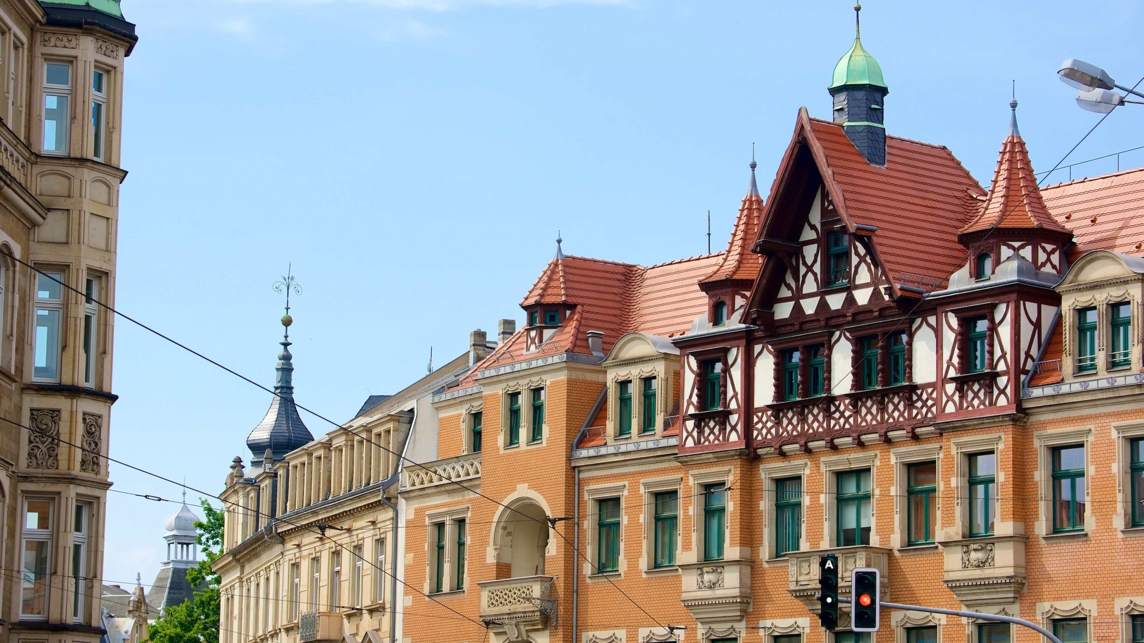A historic building with ornate architecture, including a green dome and a red-tiled roof.