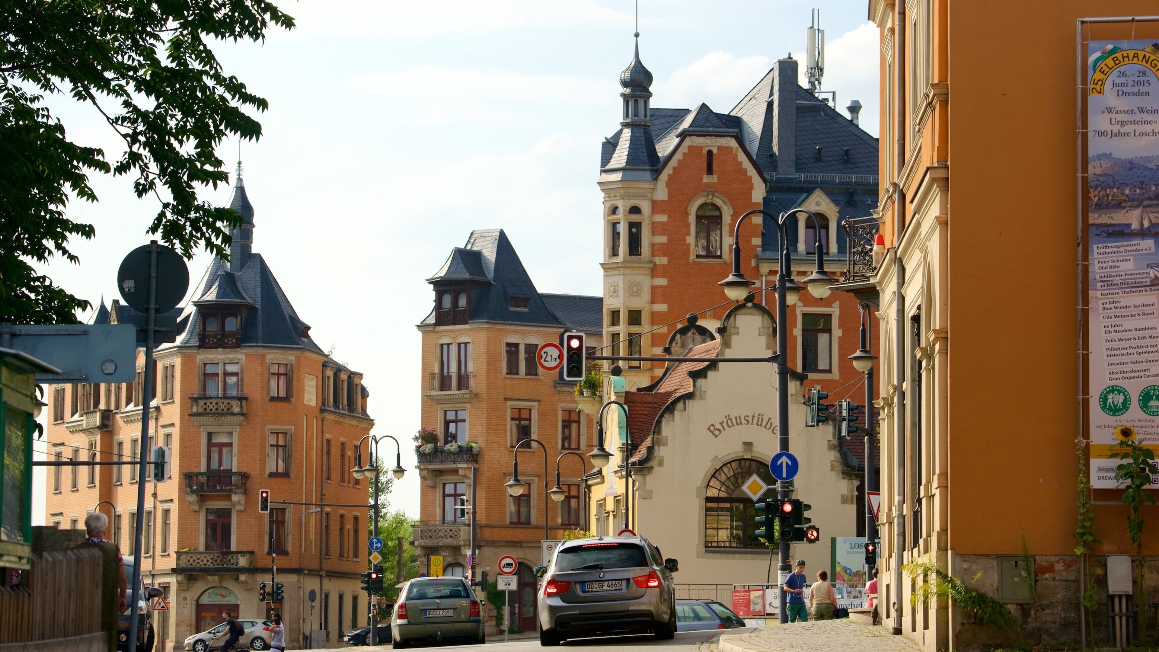 A street with historic buildings, a traffic light, and a sign for Bräustübel beer.