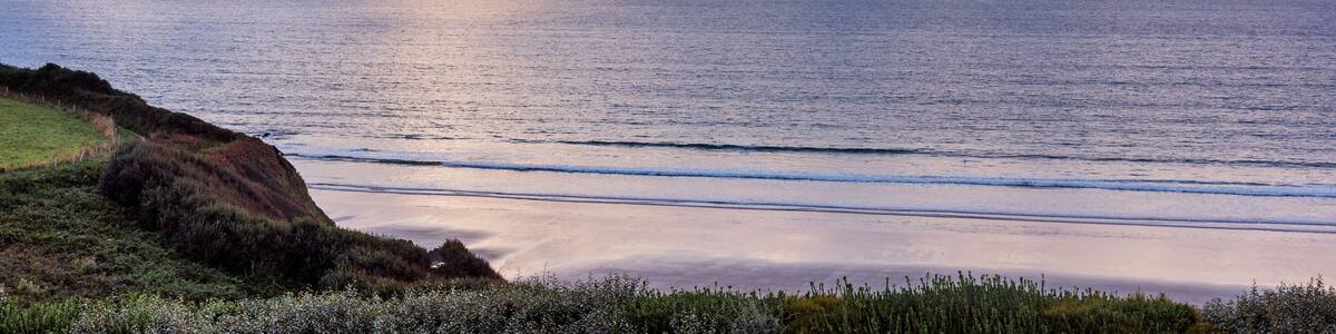 Côte de Douarnenez, mer calme, ciel nuageux, coucher de soleil imminent, atmosphère sereine et mystérieuse