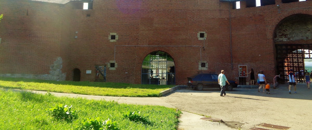 A large brick building with a tower and arched entrance.