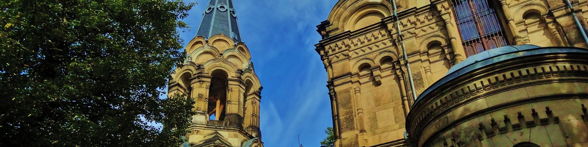 Una iglesia histórica con arquitectura ornamentada, que incluye cúpulas y una aguja.