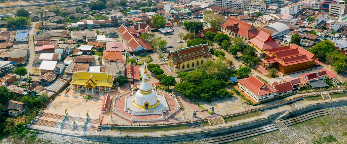 An aerial view of a historic city with traditional architecture, including temples and buildings with red roofs.