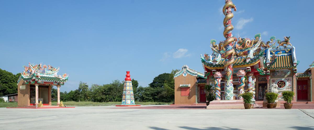 A traditional Chinese temple with ornate architecture and a dragon statue.
