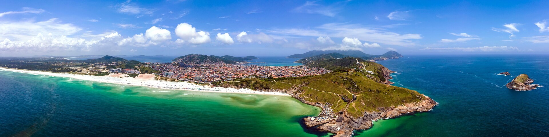 A coastal city with a beach, a mountain, and a small island.