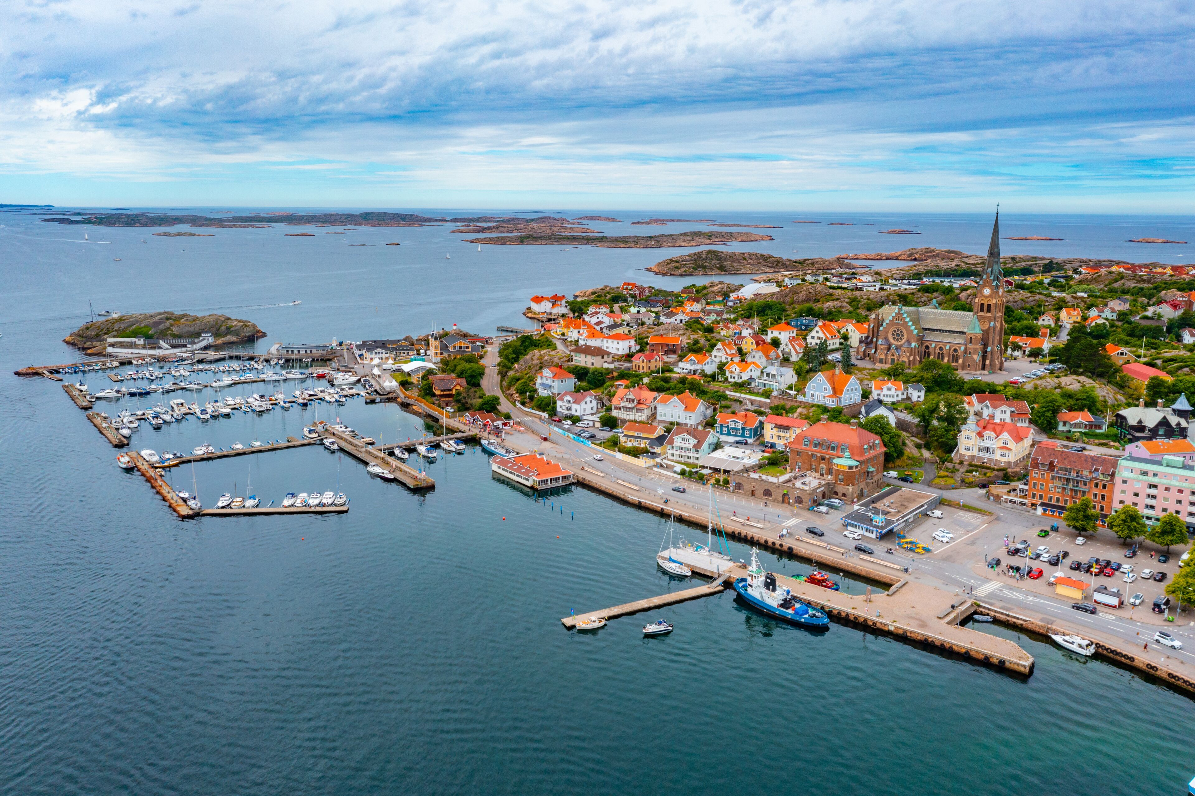 A coastal town with a prominent church, marina, and colorful houses.