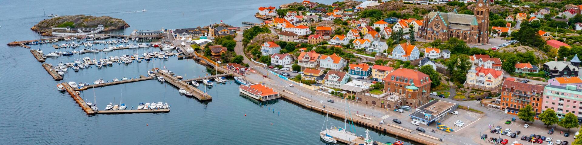 A coastal town with a prominent church, marina, and colorful houses.
