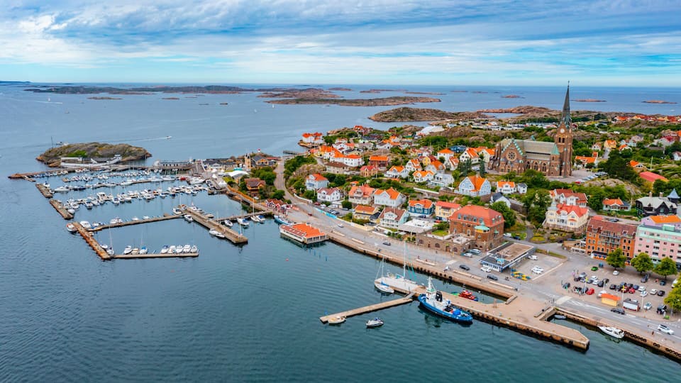 A coastal town with a prominent church, marina, and colorful houses.