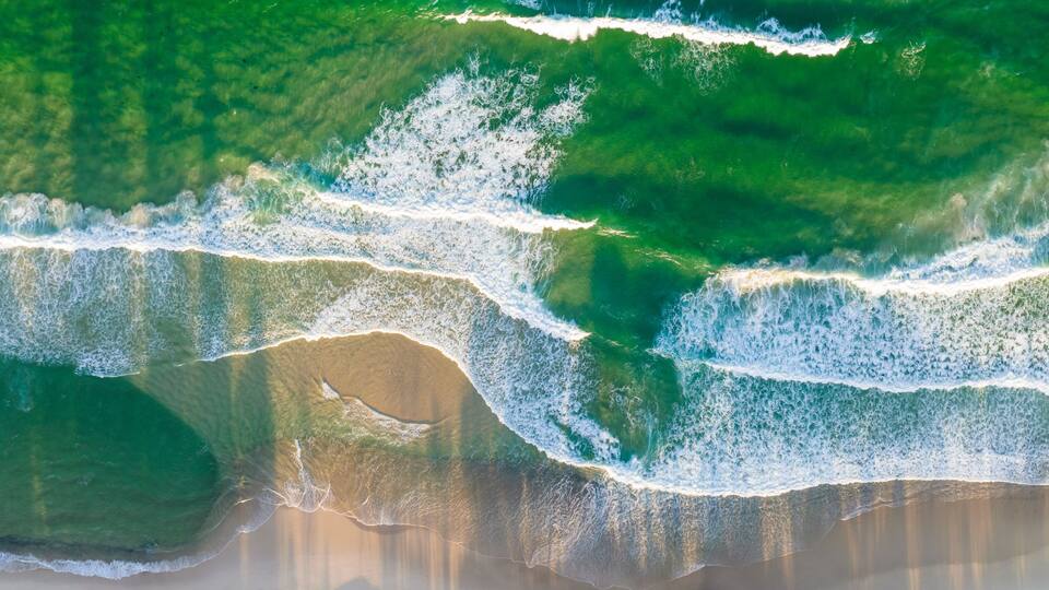 A beach with waves crashing onto the shore.