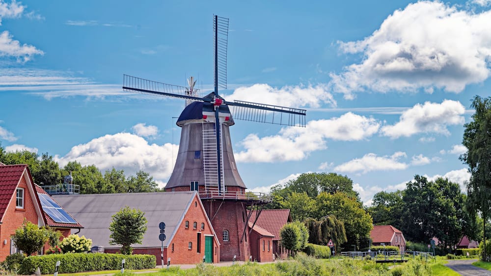 Traditional windmill with the sails positioned to show the miller is on vacation, Warsingsfehn, Moormerland, East Frisia, Lower Saxony, Germany