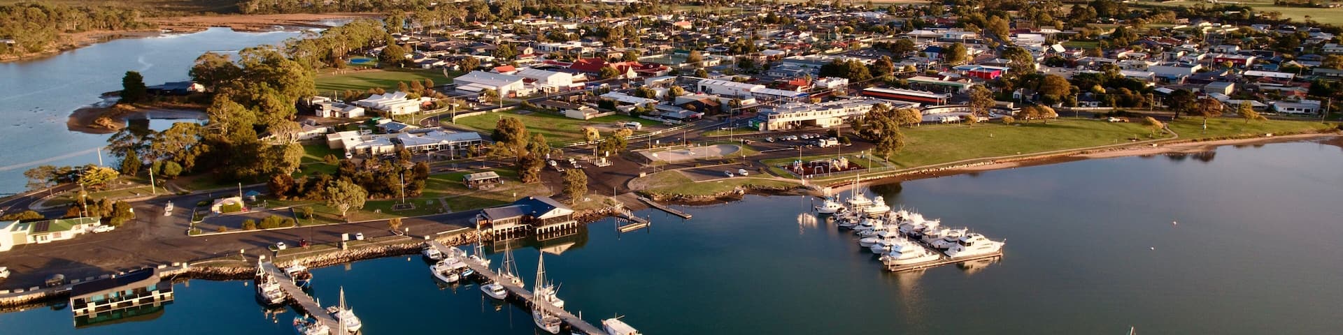 Aerial view of Saint Helens with moored boats along the shoreline. Tasmania, Australia