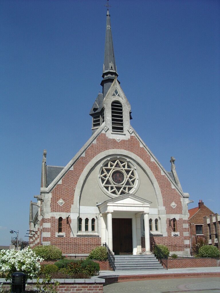 A church with a tall steeple, a large circular window, and a brick facade.