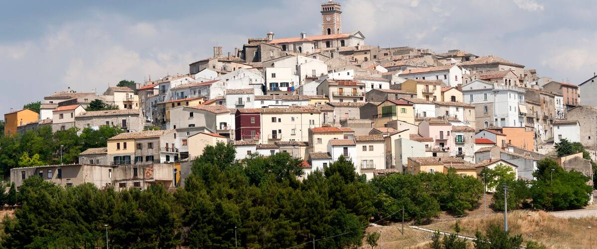 A densely packed hillside town with a prominent clock tower.