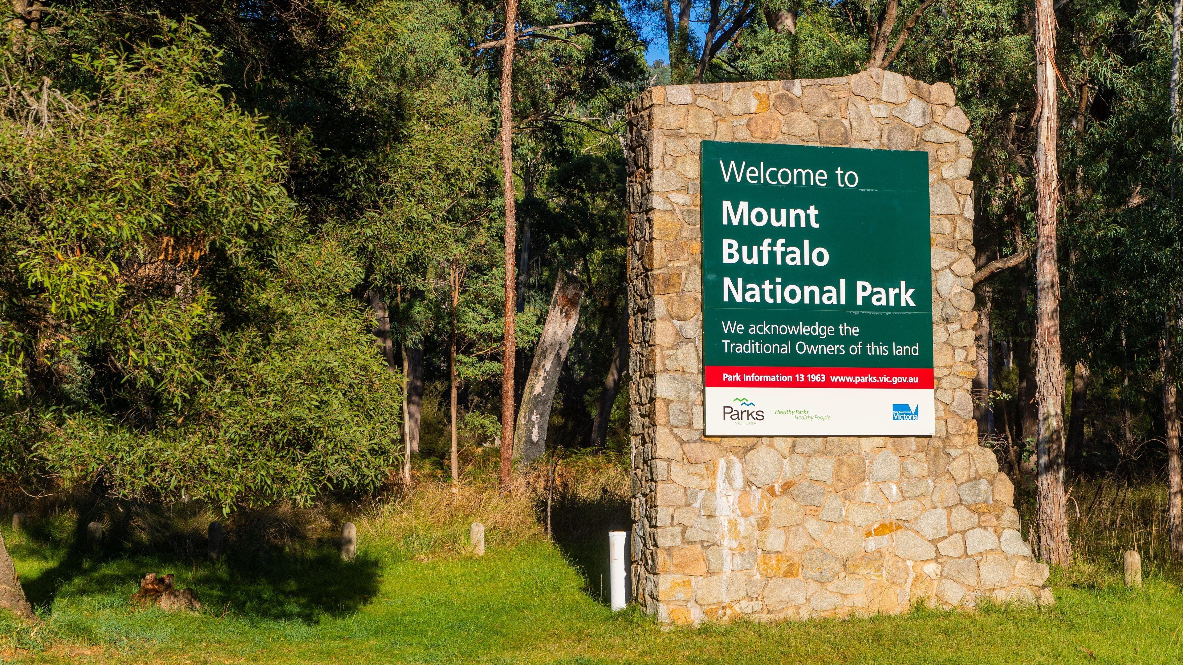 Cartell de benvinguda als visitants del Parc Nacional de Mount Buffalo, reconeixent els propietaris tradicionals del territori i proporcionant informació sobre el parc.