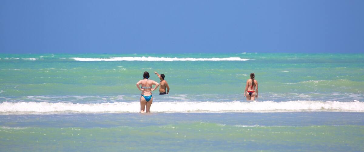 A beach with clear turquoise water and a clear blue sky.