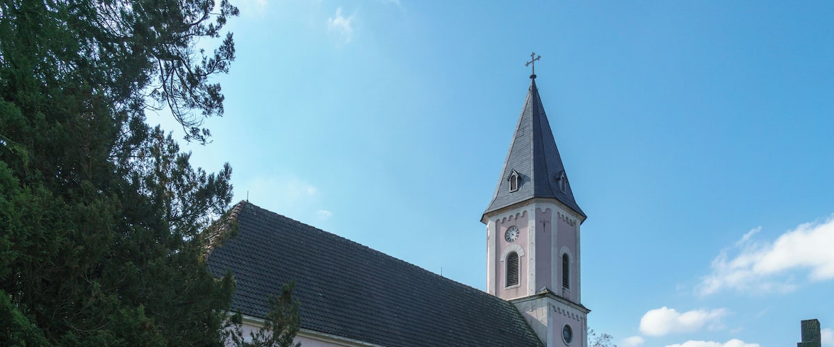 A church with a tall steeple and a clock tower.