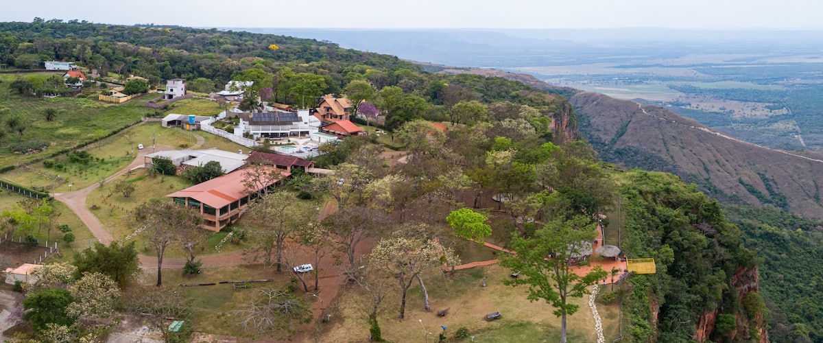 A mountainous landscape with a residential area, including houses and a swimming pool.