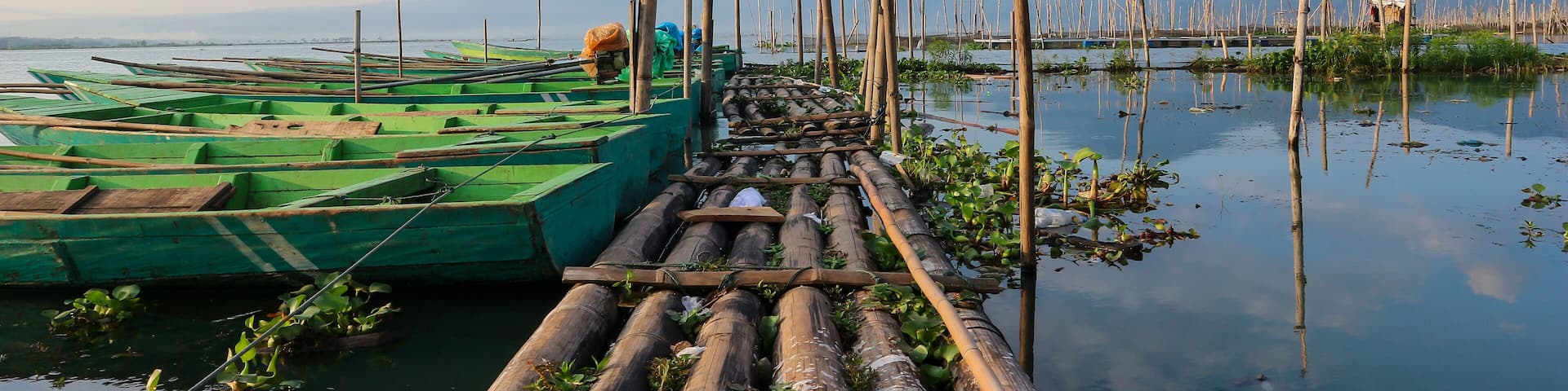Fishing boats on the shores of Rawa Pening lake. Beautiful view of Rawa Pening lake and the Merbabu and Telomoyo mountains. Fishermen at Rawa Pening lake.