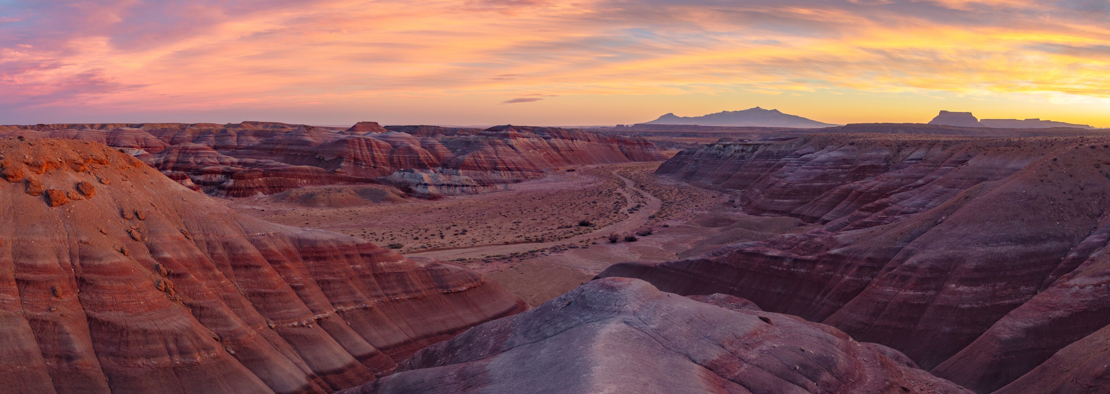 Beautiful Sunset in the desert Bentonite Hills of the southern San Rafael Swell near Hanksville Utah.  In the distance from R/L: North Caineville Mesa, Factory Butte, and the Henry Mountains.